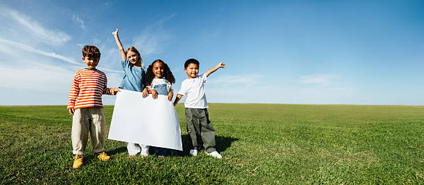 Group of happy children whit raised hands standing in the nature