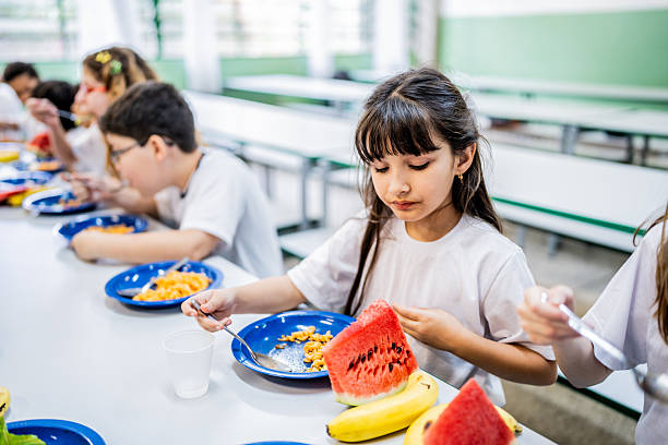 Schoolgirl having lunch in the cafeteria at school