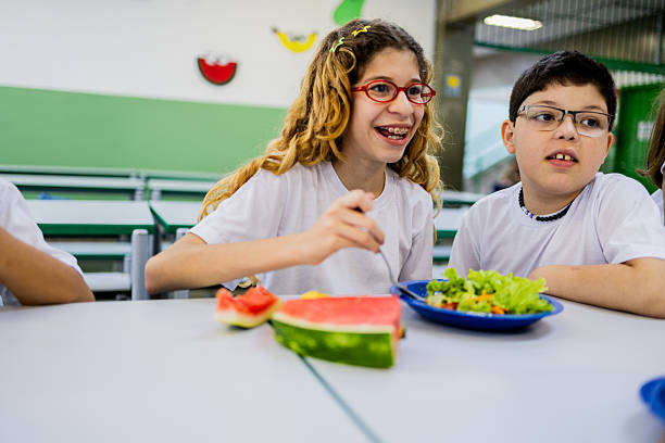 Students talking and having lunch in the cafeteria at school