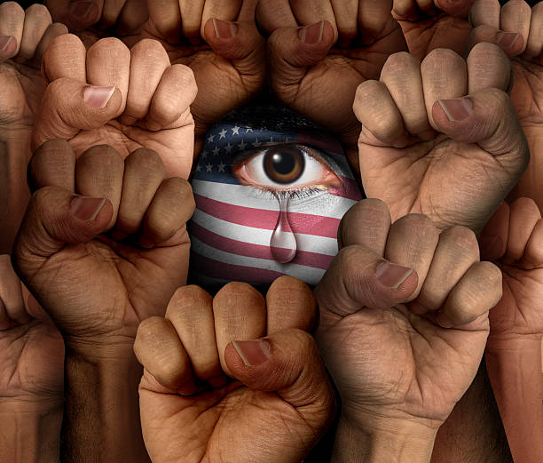 American Social Justice Crisis as United states immigration and Customs Enforcement issues and protest in America or protesting as a protester in the USA Homeland Security concept as the tear of a United States citizen with a flag painted on a face as a civil rights and discrimination metaphor.