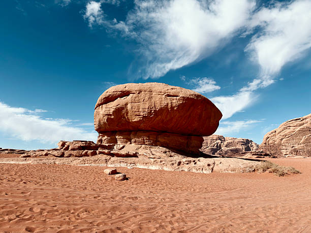 Jordan Wadi Rum Mushroom Rock Formation stands prominently in the dry Desert Landscape of the Wadi Rum Desert, showcasing geological erosion and the natural beauty of Jordan's sandstone environment. Famous Traveller`s Natural Landmark. Wadi Rum Desert, Southern Jordan, Middle East.