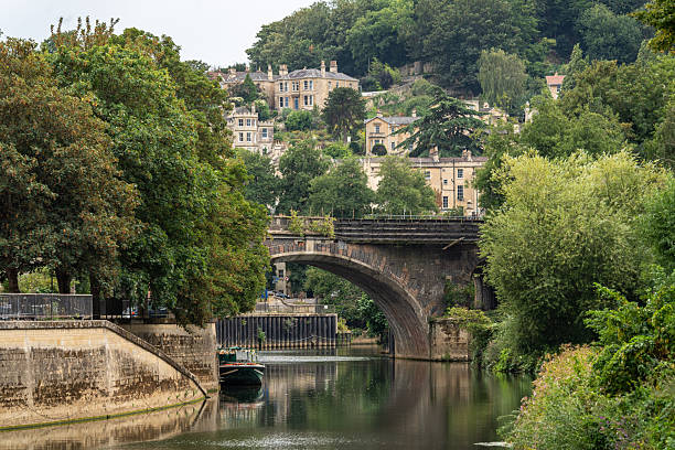The River Avon in Bath, England, featuring a historic stone bridge and charming Georgian houses, England