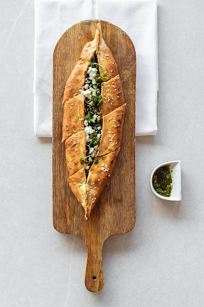 Crispy baked pide sesame bread arabic pizza with feta and spinach served in middle eastern gourmet restaurant