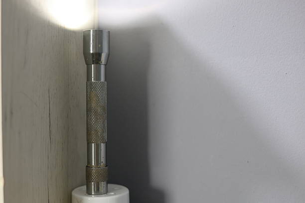 Photo of a yellow flashlight on a green background taken in a beautifully lit studio.