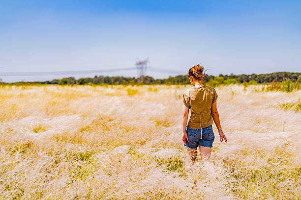 Young woman walking at a ranch, surrounded by open fields and nature