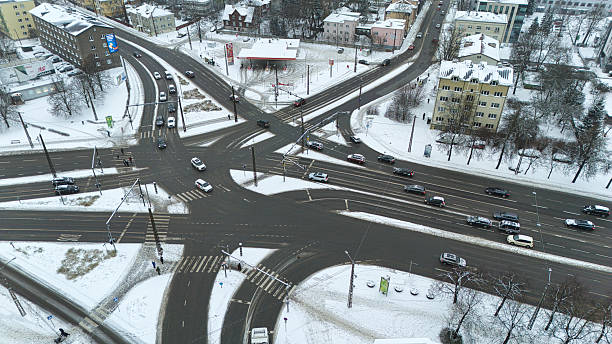 An overhead drone perspective of winter traffic and snow-covered streets in Tallinn's Kristiine district. Perfect for urban planning, transit, and cold-weather lifestyle concepts.