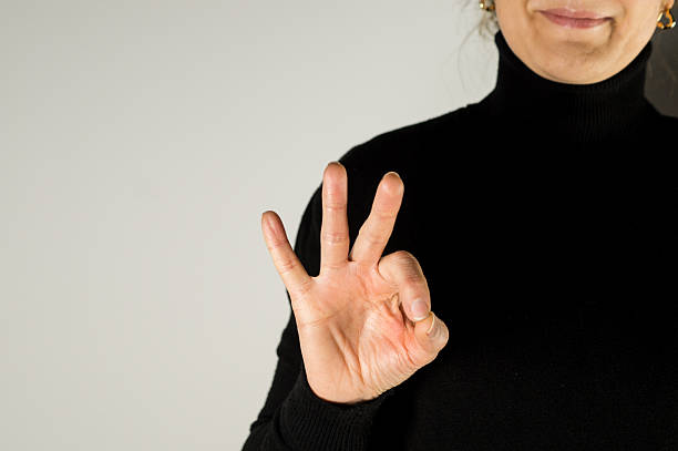 Hand showing the letter F in sign language, with the index finger and thumb touching while other fingers are raised