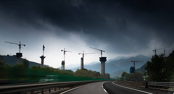 Highway bridge under construction on the mountain with storm cloud