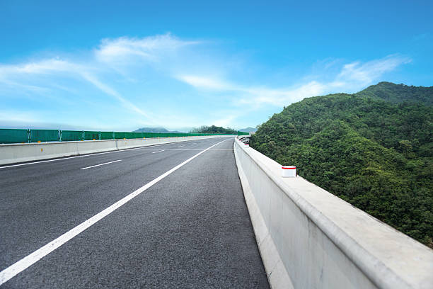 Empty asphalt road with mountain and green trees
