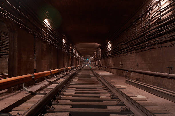 A view of a working subway tunnel. The train's tracks are laid on the floor. A contact rail, which supplies electricity, is mounted to the side.
