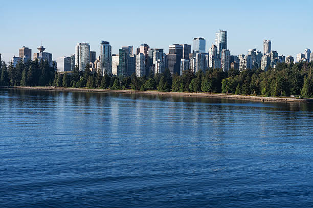 Vancouver, Canada - October 11, 2019: Scenic cityscape view of Vancouver skyline and Burrard Inlet from Stanley Park at sunny day