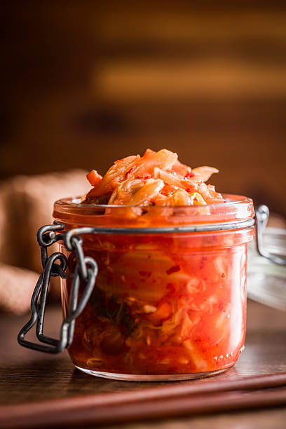 Fermented cabbage. Kimchi. Korean food in jar on a wooden table.