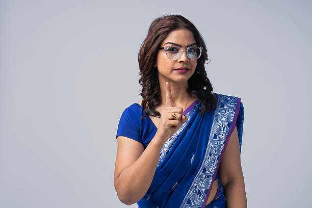 Portrait of a beautiful young woman, a fashion model, wearing a blue color headscarf, studio shot in front of a white background