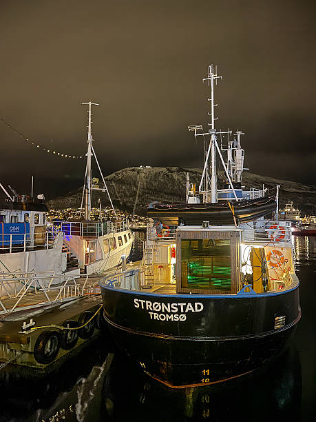 Tromso, Norway - December 21, 2025: Winter polar night. Stronstad boat in port