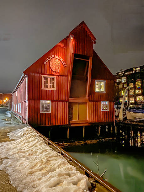 Tromso, Norway - December 21, 2025: Winter polar night. Polar Museet, museum in historic wooden building on stilts in the port