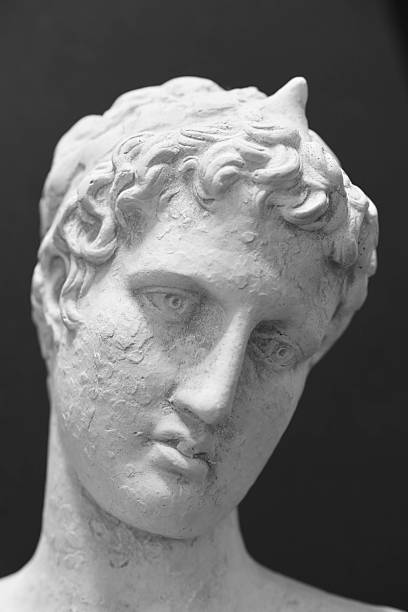 A close-up view of a classical marble bust, featuring curly hair, a serene, contemplative expression, and a softly weathered surface. This timeless sculpture captures the quiet dignity of antiquity, perfect for art, history, and design contexts. Suitable for editorial and creative stock use.