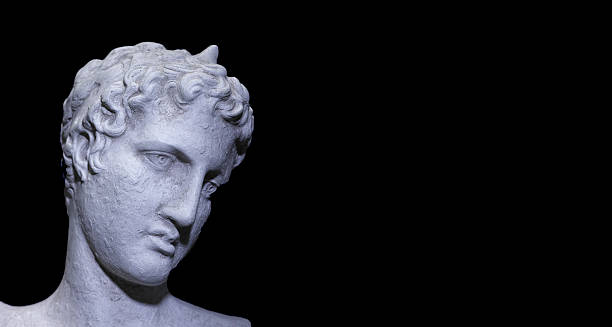 A classical marble bust shown in cool, moody lighting that emphasizes the sculpted curls, thoughtful gaze, and refined texture of the statue. This serene, timeless portrait conveys contemplation, artistry, and antique elegance, perfect for art catalogs, design references, and gallery showcases. Denotes classical influence and refined craftsmanship.
