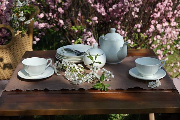Beautiful spring flowers on table served for tea drinking in garden