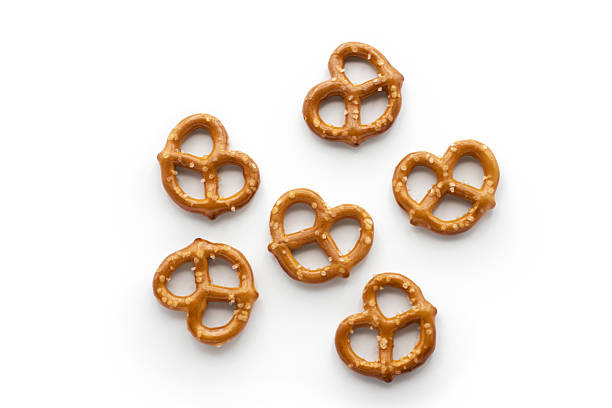 Top view of wooden spoon with salty snack pretzels on and beneath it