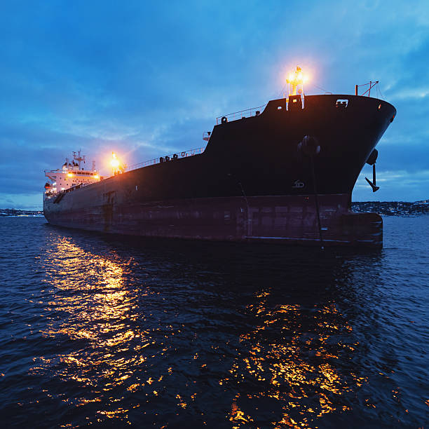 A water level view of an oil tanker ship anchored in a harbor.
