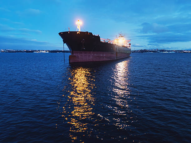 A water level view of an oil tanker ship anchored in a harbor.