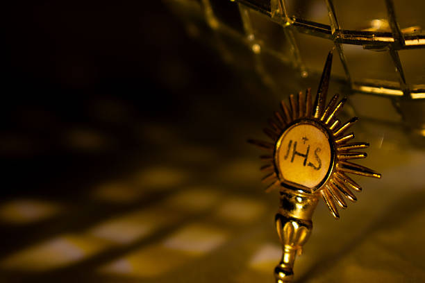 Golden Eucharistic monstrance holding the consecrated host, symbol of Christian faith, devotion, worship and spirituality. Conceptual religious image suitable for Catholic themes, prayer, church, belief and sacred celebrations.