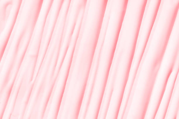 A close-up of a pink binder cover with a flashlight shining at it, reveals both dotted patterns and various lines running horizontally and vertically, sometimes intersecting.