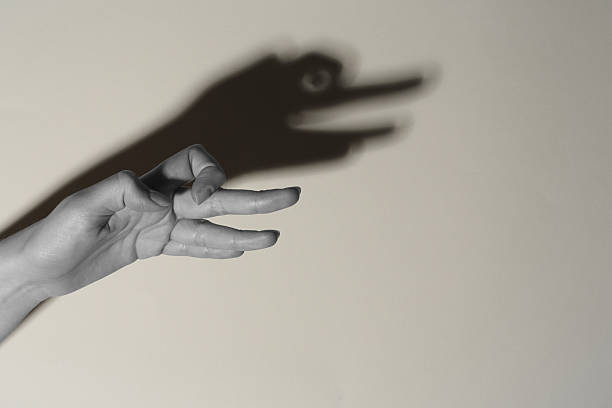 istock Shadow puppet. Woman making hand gesture like goose on light background, closeup with space for text. Black and white effect 2258788576