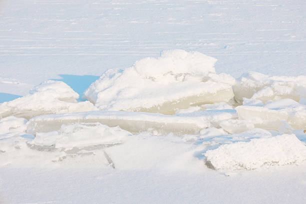 Pristine snow blankets fractured ice formations, creating a striking frozen winter landscape.