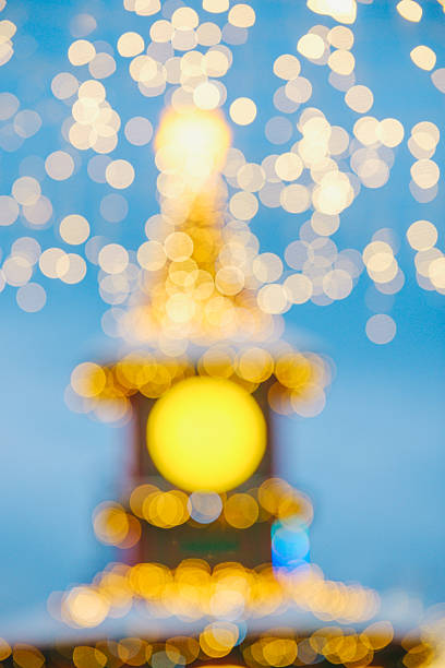 Soft golden festive lights bokeh effect on blue background. Blurred bright celebration scene.