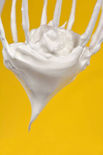 Meringue on a whisk over yellow background