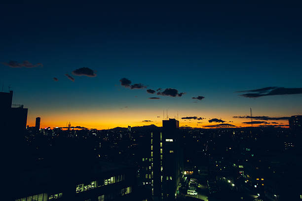 A wide view of Tokyo’s urban skyline at twilight, captured just after sunset.The glowing horizon contrasts with the deep blue evening sky and illuminated buildings, creating a calm yet metropolitan atmosphere.
