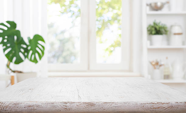 istock Bleached wooden table top on blurred kitchen window and shelf interior background 2258797994