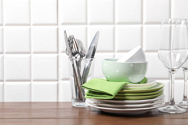 Stylish table setting with white dishware on white tablecloth close up