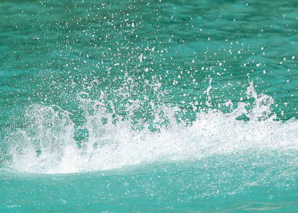 A splash of water in the ocean. The water is blue. The splash is small