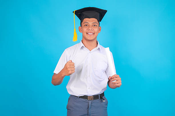 Young Man Celebrating Graduation With Triumphant Gesture