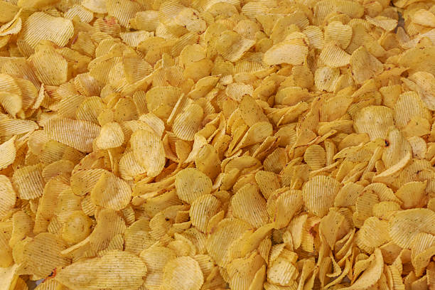 Closeup view of potato golden chips. Production of big snacks factory.