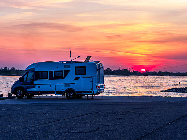RV motorhome camping by river at sunset in Druten