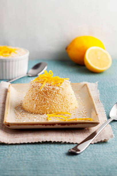 Creamy lemon and coconut mousse topped with fresh zest and shredded coconut. A refreshing, light gourmet dessert served on a rustic pla