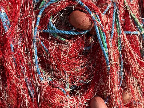 Fishing nets and floats in vibrant red and blue creating a textured abstract background. Mobile photo