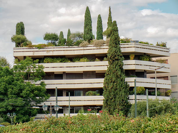 Modern building with rooftop garden and lush vegetation in Athens, Greece. Example of sustainable architecture, green design and integration of nature into urban environment in a Mediterranean city.