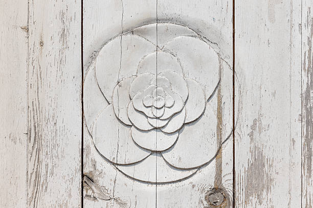 A white wood plank background features a circular rosette carving with layered petals. This rustic, vintage motif adds charm, texture, and an elegant focal point for home decor projects