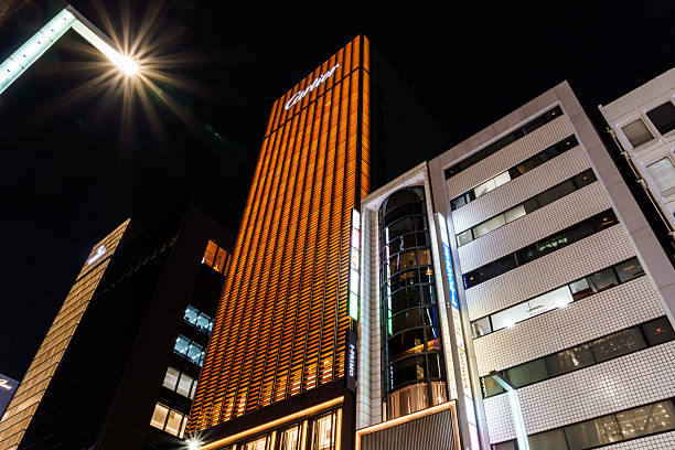 Tokyo, Japan - August 3, 2024: Illuminated buildings in the Ginza district of Tokyo at night, showcasing modern architecture and vibrant city lights.