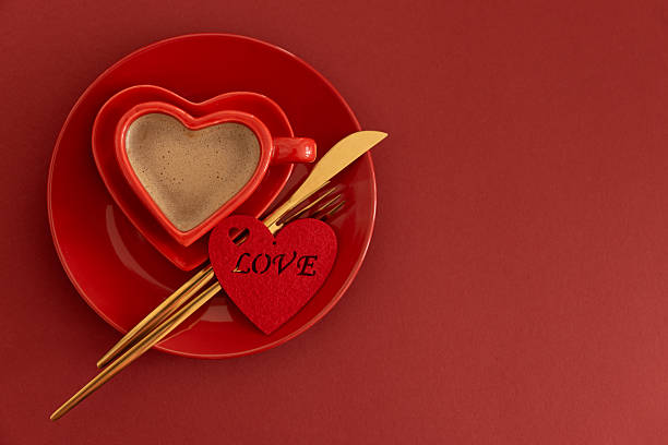 Heart Shaped Coffee Cup with Felt Heart.  Romantic Valentines Day Table Setting on Red Background
