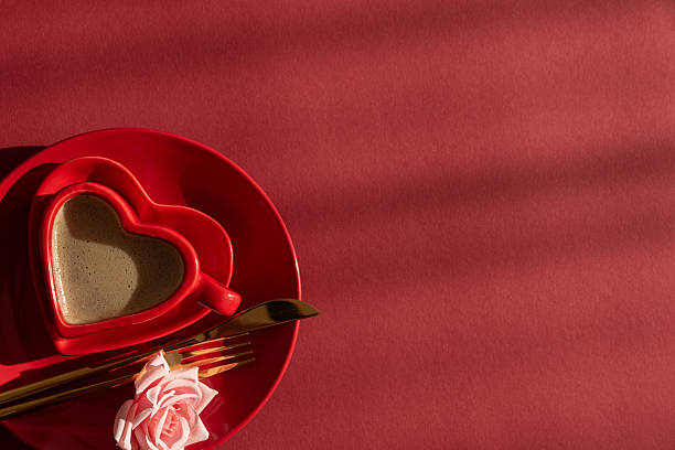 Heart Shaped Coffee Cup with Rose. Romantic Valentines Day Table Setting on Red Background