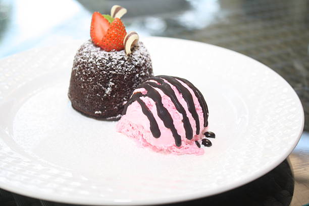 Features a decadent chocolate lava cake topped with fresh strawberries, powdered sugar, and served with a scoop of strawberry ice cream drizzled with chocolate sauce