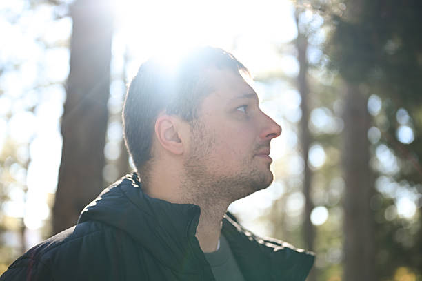 istock Young adult man enjoying sunlight in tranquil forest 2258937887