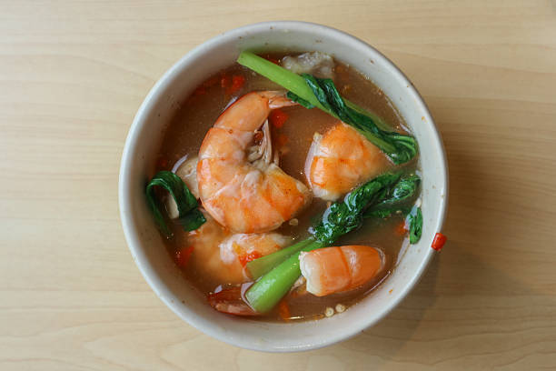 Shrimp soup with spicy sauce served in a white bowl.