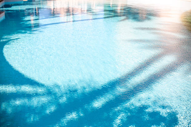 Woman swimming in a hotel pool with resting spots nearby. Tropical resort. Summer activities on Maldives