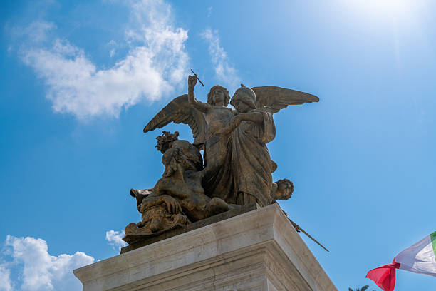 Statue of a melancholic female figure in front of a cross. Cloudy day, atmosphere of sadness.